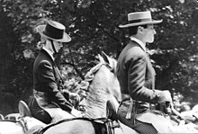Photographie en noir et blanc d'une femme et d'un homme, montant à cheval et coiffés de chapeaux cordobés.