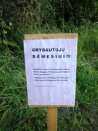 A sign in a Lithuanian forest warning of high risk of tick-borne encephalitis infection
