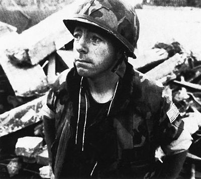 Navy Chaplain (Fr.) George Pucciarelli wears a stole over his Marine Corps camouflage uniform that he donned to deliver Last Rites after the 1983 truck bomb attack. He tore off a piece of his uniform to make a new kippa for Jewish chaplain Arnold Resnicoff, as they ministered side-by-side to all Marines