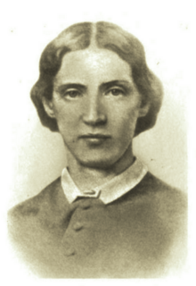 B&W portrait photo of a woman with short brown hair, wearing a dark blouse with a white collar.