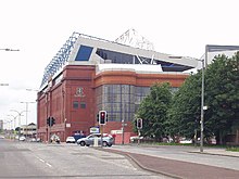 A view of the Main Stand in 2005. The Club Deck (white) was constructed above the 1928 Main Stand in the early 1990s. The brick and glass construction in front is an enclosed stairwell to the upper deck. Ibrox Stadium - geograph.org.uk - 21482.jpg