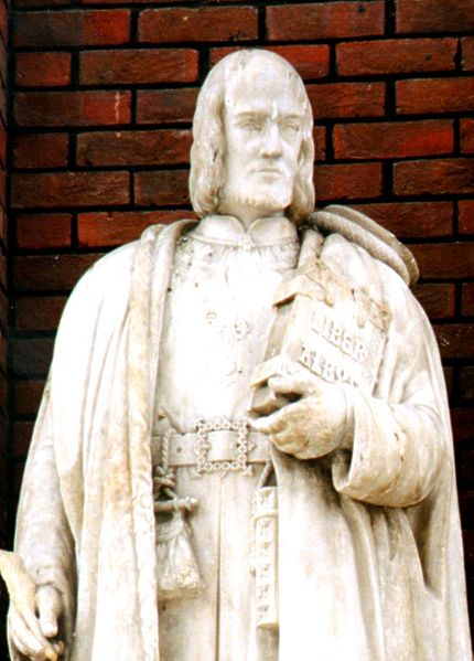 Statue of John Carpenter (1372–1442) by Samuel Dixon situated on the wall of the City of London School's glassed ceiling atrium standing over the door