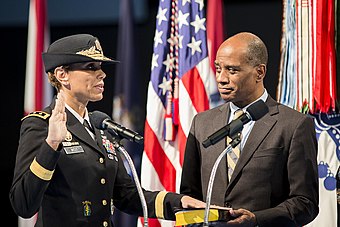 Incoming Army surgeon general Lt. Gen. Nadja West takes the oath of office as her husband, retired colonel Donald West, holds a Bible during her promotion ceremony on February 9, 2016.