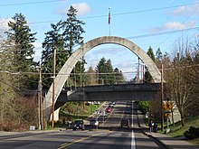 Photograph of a concrete arch bridge with a roadway running beneath
