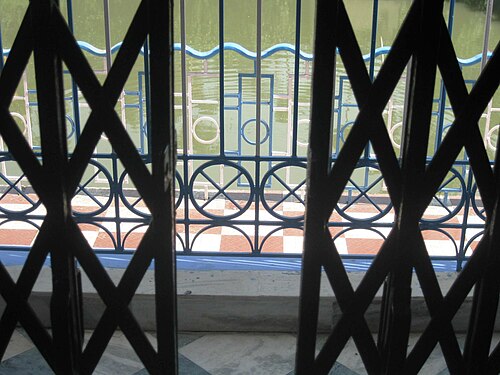 Peeping through a collapsible gate, Kolkata, West Bengal, India.