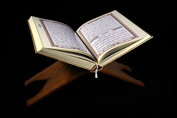 A Quran manuscript resting on a rehal, a book rest for the holy text