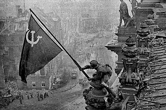 A Russian soldier raising the Soviet flag over the Reichstag during the Battle of Berlin Raising a flag over the Reichstag 2.jpg