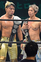 Sho (left) and Yoh (right) as the IWGP Junior Heavyweight Tag Team Champions in November 2017 Roppongi 3K IWGP Junior Heavyweight Tag Team Champions.jpg