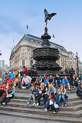 Tourists sitting on the steps of the Shaftesbury Memorial Fountain Statue of Eros.jpg