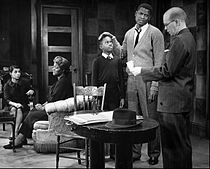 Photo of a scene from the play A Raisin in the Sun. From left: Dee, (Ruth Younger); Claudia McNeil, (Lena Younger); Glynn Turman, (Travis Younger); Sidney Poitier, (Walter Younger) and John Fiedler, (Karl Lindner).