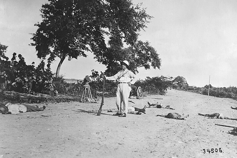 File:American poses with dead Haitian revolutionaries after being killed by US Marine machine gun fire - 10-11-1915.jpg