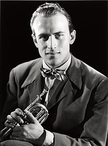 A greyscale picture of Boris Vian wearing a bowtie and holding a trumpet.