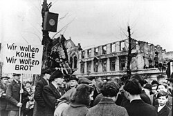 The hunger-winter of 1947, thousands protest in West Germany against the disastrous food situation (March 31, 1947). The sign says: We want coal, we want bread Bundesarchiv Bild 183-B0527-0001-753, Krefeld, Hungerwinter, Demonstration.jpg