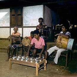 COLLECTIE TROPENMUSEUM Muzikanten tijdens het bespelen van een totobuang en trommen Amahusu TMnr 20018289.jpg