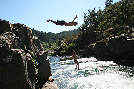 Man and woman jumping off a cliff in Colliding Rivers, Glide, Oregon