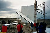Volunteers use a scaffold to erect the walls of the station on July 21, 2000.