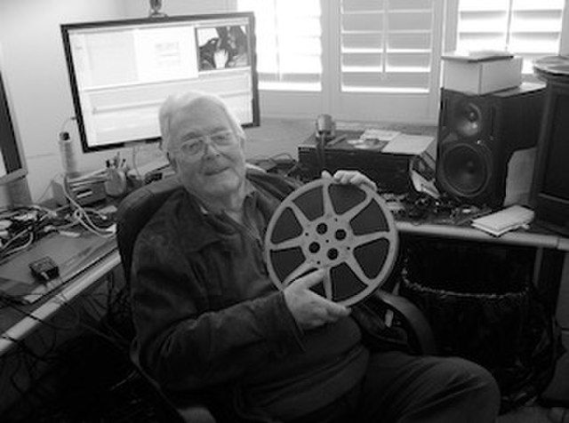 Ferde Grofe Jr holding a 16mm print of the film The Day of the Wolves