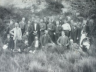 a historic photograph of a group of men posing in long grass