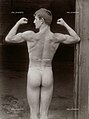 M 1986 recto. "Der Vetter aus Weimar". Culturista nudo di spalle. / Back shot of a bodybuilder. Cm 16,8x22,5.