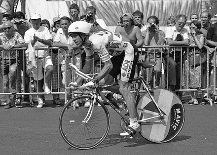 Greg LeMond holding low-profile 'bullhorn' handlebars, with tri-bars in between his arms, at the 1989 Tour de France.