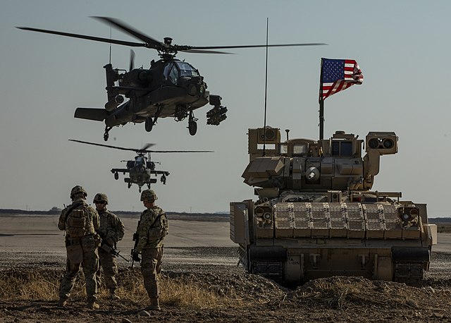 1st Armored Division infantry, an M2 Bradley armored vehicle, and AH-64 Apache attack helicopters as part of Combined Joint Task Force – Operation Inh