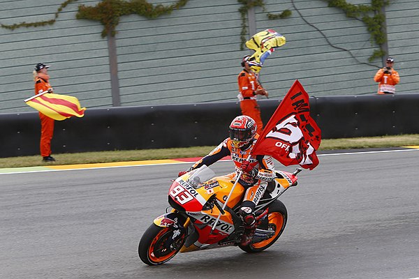 Marc Márquez, celebrating with his flag after winning the MotoGP race.