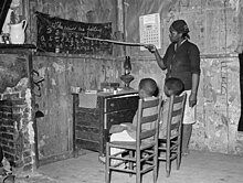 Mother teaching her children, 1939, Transylvania, Louisiana Mother teaching children numbers and alphabet in home of sharecropper, Transylvania, Louisiana, 8b37034.jpg