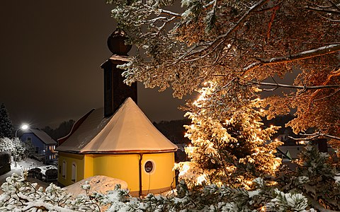 Ortskapelle von Niederschrems mit beleuchtetem Weihnachtsbaum