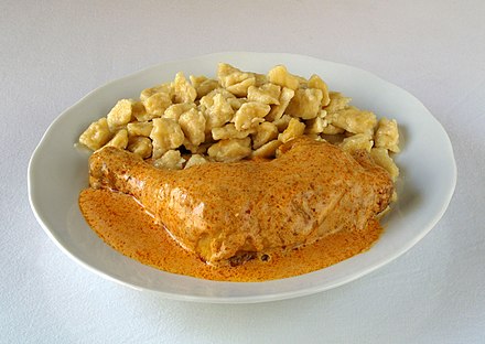 Chicken paprikash (csirkepaprikás) simmered in thick creamy paprika gravy with home made pasta called nokedli.