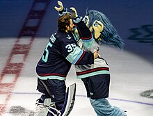 Kraken goaltender Joey Daccord hugging Buoy after a game in 2023. Philadelphia Flyers at Seattle Kraken - December 29, 2023 - Joey Daccord hugging mascot Buoy (53432586990).jpg