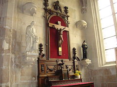 Retable classique (provenant du collège des Ormeaux du Havre), en bois. L'influence classique se voit sur des éléments comme les flambeaux et la tête d'ange sculptée en haut du retable, qui porte en son centre une croix avec une plaque. Le retable est entouré par les statues de saint Joseph et de sainte Rita.