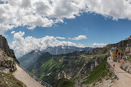 Rifugio Achille Papa s údolím Val Canale, Strada degli Eroi a skupinou Carega v pozadí.