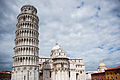 The Leaning Tower of Pisa "leaning towards" Pisa Cathedral (Duomo di Pisa), dome of the Camposanto ("Holy Field"), Piazza dei Miracoli ("Square of Miracles"). Pisa, Tuscany, Central Italy.