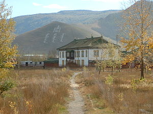 Two-story, Russian-style house with a stream in the foreground