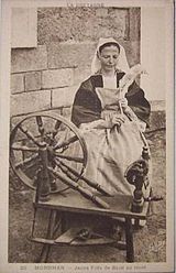 Postkort av ung fransk kvinne ved rokken ca. 1910.