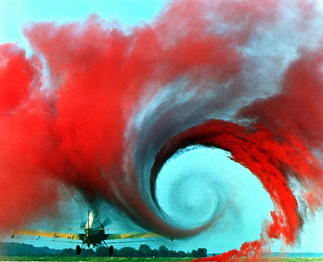 The air flow from the wing of this agricultural plane is made visible by a technique that uses colored smoke rising from the ground. The swirl at the wingtip traces the aircraft's wake vortex, which exerts a powerful influence on the flow field behind the plane.