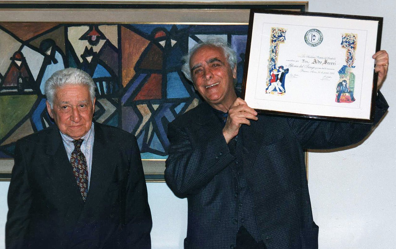 File:Aldo Severi recibe el “Diploma a la Gloria del Tango”, de manos de José Gobello, la Academia, del Lunfardo. Año 1997.jpg - Wikimedia Commons