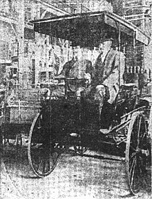 Lew Arntz and Morrison seated in an electric automobile