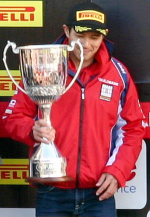 Kiyonari in Buildbase BMW colours acknowledging spectators' plaudits at Brands Hatch Showdown podium, end of BSB season 2014