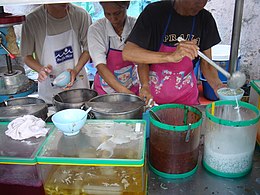 Cảnh nhân viên một quầy tráng miệng đang bán cendol cho khách tại Penang, Malaysia