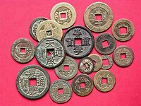 Numerosas moedas com orifícios quadrados e com caracteres chineses inscritos