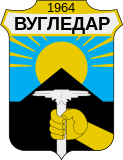 Герб Вугледара — кирка на тлі терикону символізує видобуток вугілля