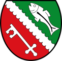 Gemeinde Loiching Durch einen oben dornenförmig, unten lappenförmig gestalteten silbernen Schrägbalken geteilt von Grün und Rot; oben ein schräger silberner Fisch, unten ein schräger silberner Schlüssel.