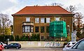 Wohnhaus mit Einfriedungszaun und Teile des parkähnlich gestalteten Gartens mit Bassin und Solitärbaum