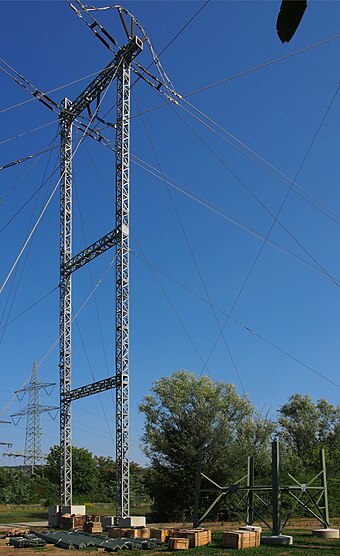 Temporary guyed pylon next to a commenced new tower