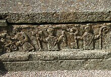 A bishop with other officials on an 11th-century grave in Sweden Husaby Church 2013 people on 11th Century gravestone.jpg