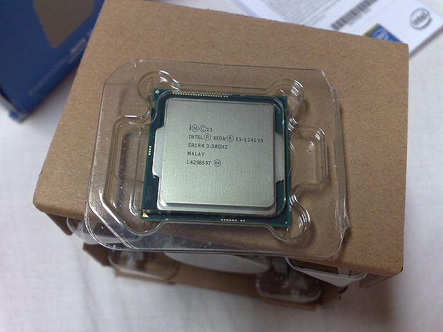 Intel Xeon E3-1241 v3 CPU, on top of its original packaging with an OEM fan-cooled heatsink