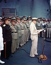 MacArthur at surrender ceremony. The flag flown by Perry is visible in the background. Japanese-surrender-mac-arthur-speaking-ac02716.jpg