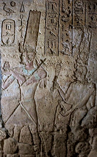 Gebel Barkal, Temple of Mut: Taharqa, followed by the sistrum shaking queen Takahatamun making offerings to Amun and Mut. JebelBarkalMutTemple2.jpg