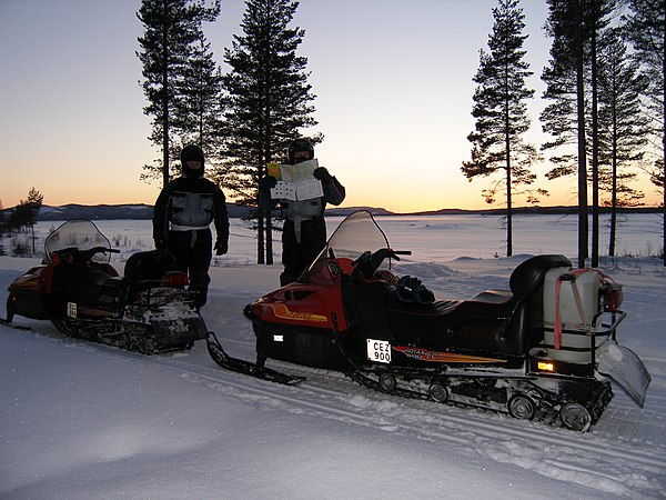 Two Swedish snowmobiles with license plates attached to the side of the vehicles